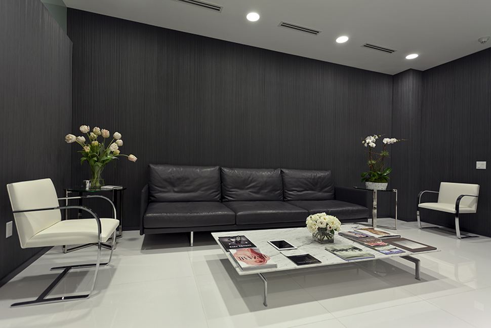 Waiting room of Dr. Herman's office with a black couch and white chairs